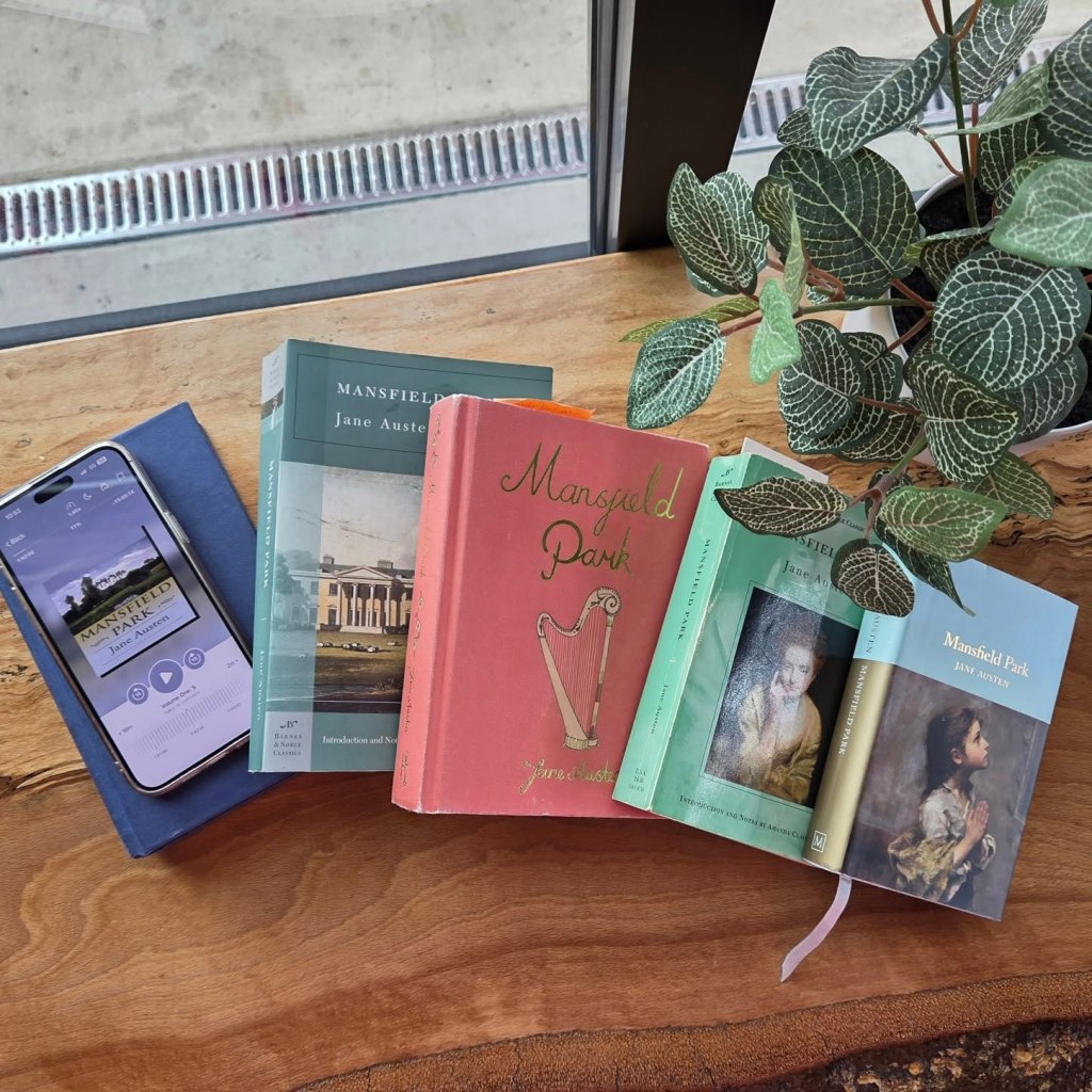Multiple copies of Mansfield Park, including an audiobook version on a mobile device